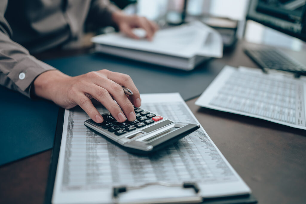 Investors working on desk office and using a calculator to calculate